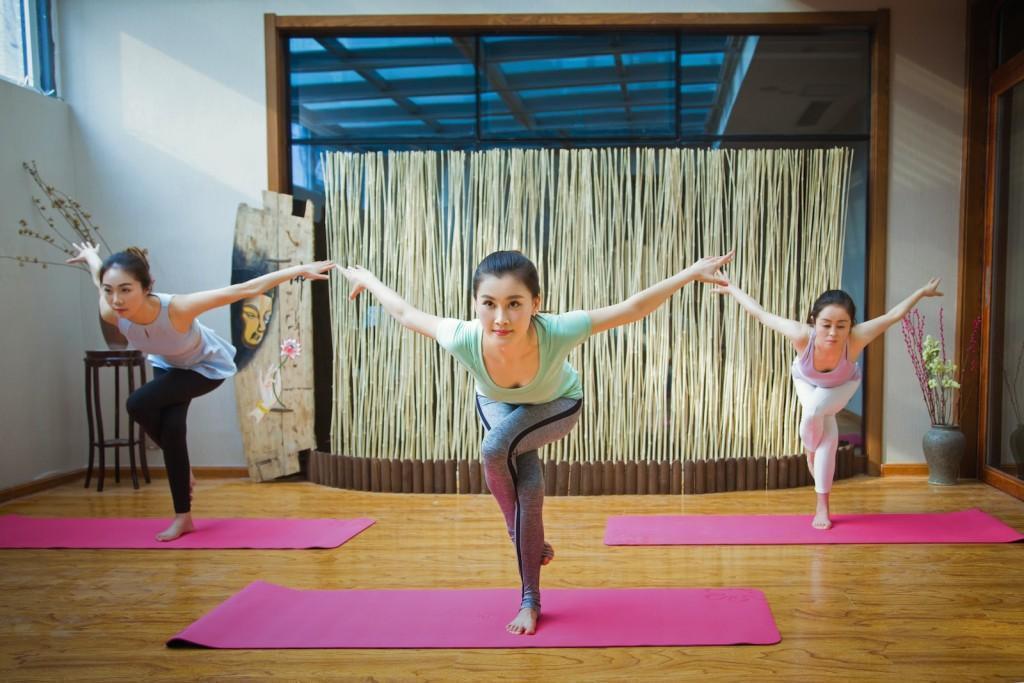 2 women in pink tank top and pink leggings doing yoga